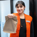Woman holding brown lunch bag