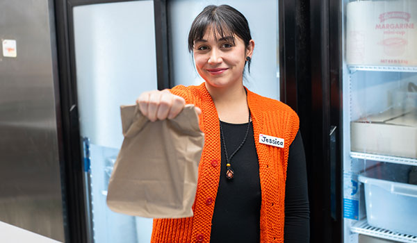 Woman holding brown lunch bag