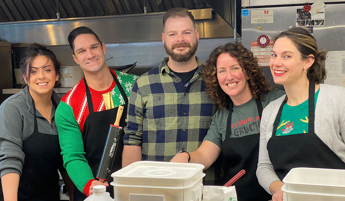 People smiling in kitchen while donating time