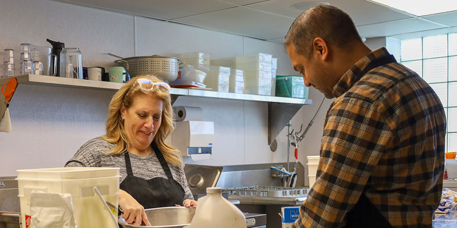 male and female in kitchen volunteering