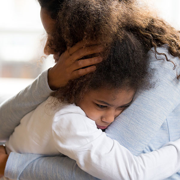 Mother with black hair hugging child